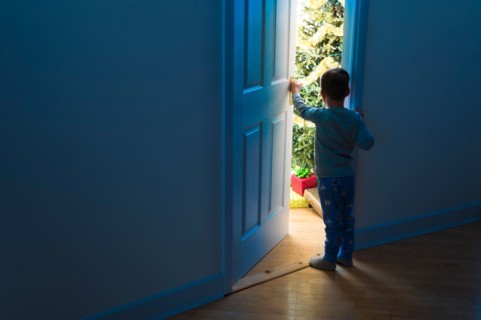 Boy (4-5) peeking through doorway.