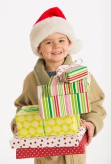Portrait of boy (4-5) carrying christmas presents.