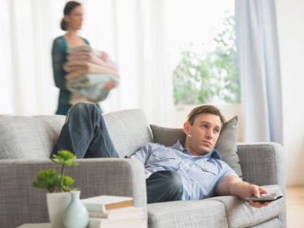 Man lying on sofa watching tv.