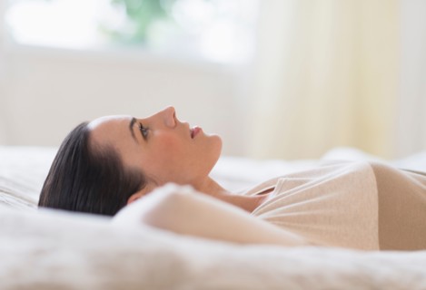 Woman lying on bed.