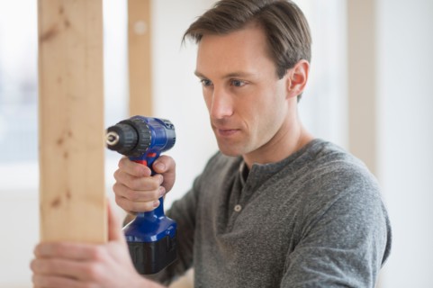 Man using hand drill.