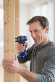 Man using hand drill.