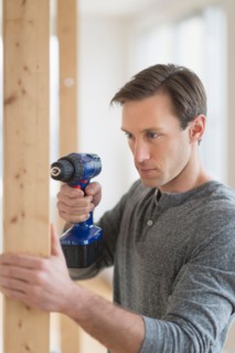 Man using hand drill.