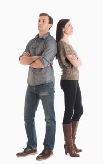 Couple standing back to back.