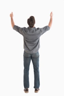 Rear view of man raising arms.