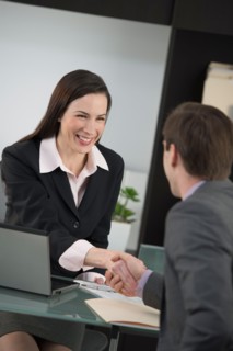 Businesswoman and businessman shaking hands.