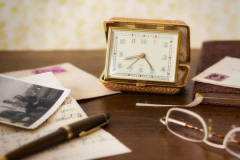 Still life with clock, spectacles and old photos .