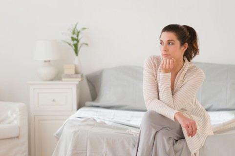 Woman sitting on bed.