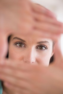 Woman looking at camera through handsframe.