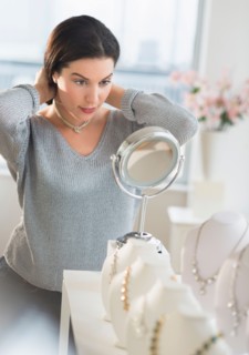 Woman trying on necklace.
