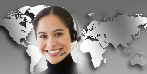 Woman with headset with world map in background.