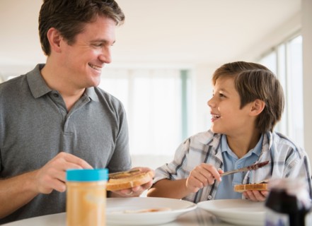 Father and son (8-9) eating lunch