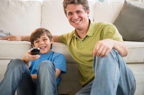 Father and son (8-9) watching television