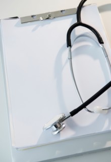 Studio shot of stethoscope and clipboard with blank paper