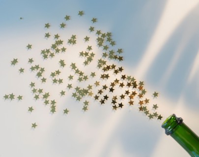 Star shape confetti splashing out of champagne bottle