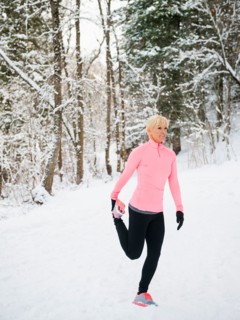 Woman exercising in winter forest