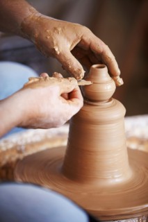 Hands working with clay on potter's wheel