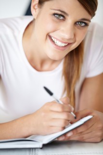 Portrait of young woman writing in notepad