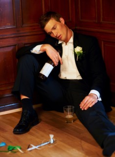 Drunk groom sitting on floor