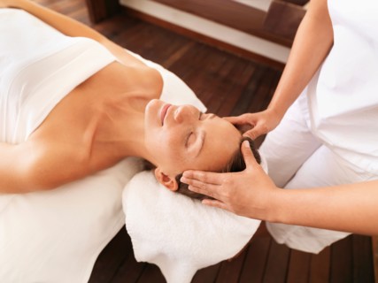 Woman getting facial massage in spa