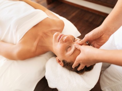 Woman getting facial massage in spa