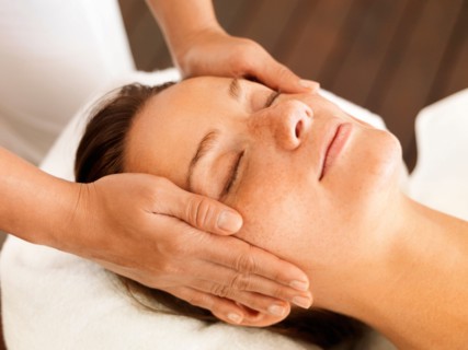 Woman getting facial massage in spa
