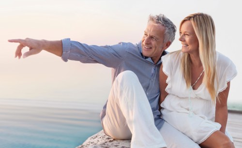 Mature couple sitting by seashore