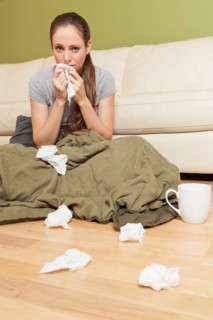 Woman in living room blowing her nose