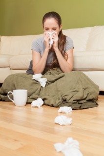 Woman in living room blowing her nose