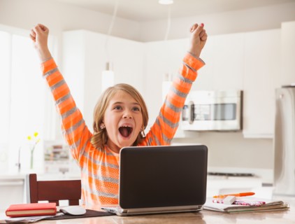 Excited girl (6-7) with laptop