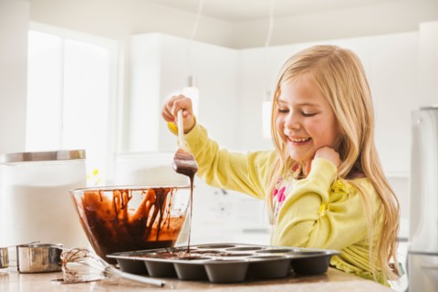 Girl (6-7) baking cupcakes