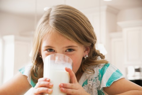 Girl (6-7) drinking milk