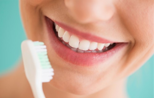 Close-up of woman brushing teeth.