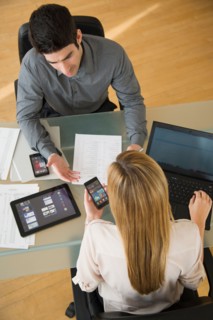 Business man and woman using mobile devices.