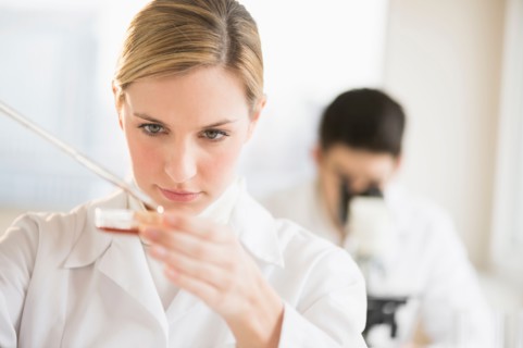 Scientist using pipette and petri dish.