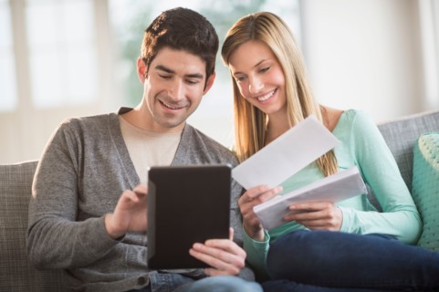 Couple using tablet pc to pay bills online.