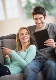 Couple using tablet pc and smartphone.
