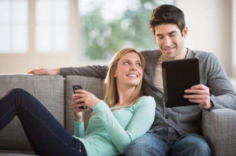 Couple using tablet pc and smartphone.