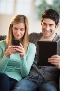 Couple using tablet pc and smartphone.