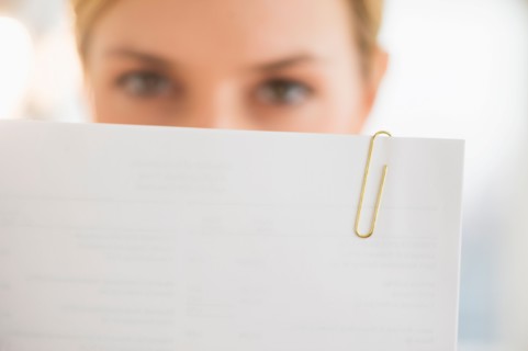 Close-up of young woman reading documents.