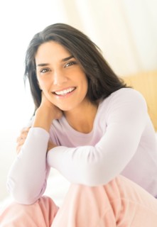 Woman sitting on bed.