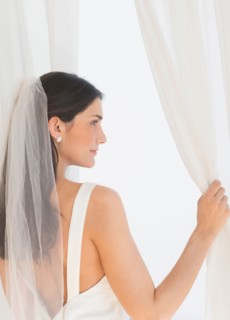 Bride looking through window.