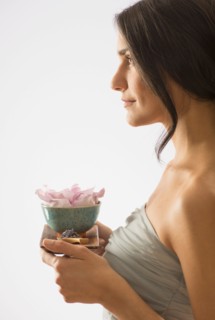 Woman holding tray with scented flower.