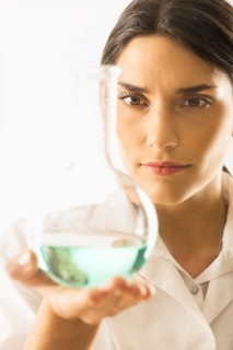 Woman holding beaker with liquid.