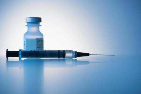 Close up of syringe and medication, studio shot.