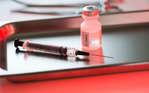 Close up of syringe and medication, studio shot.