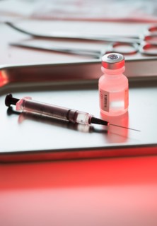 Close up of syringe and medication, studio shot.