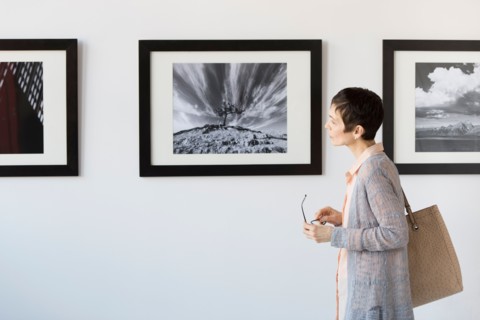 Woman watching photographs in art gallery.