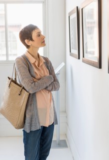 Woman watching photographs in art gallery.