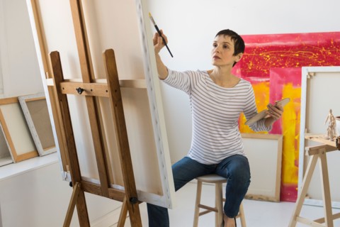 Female artist painting in her studio.